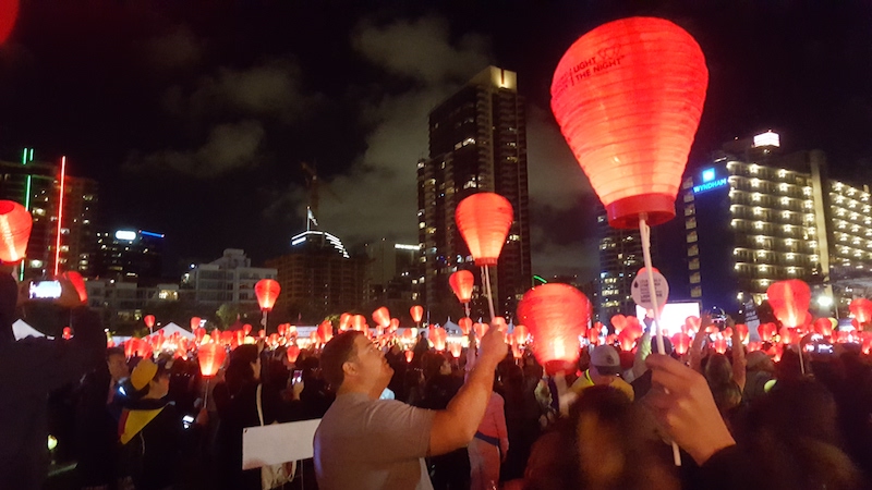 a crowd with lanterns at the Leukemia Lymphoma Society's Light the Night